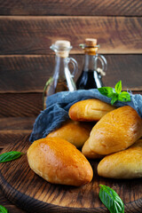 Traditional Russian cabbage pies on wooden background. Baked homemade pirozhki with cabbage