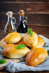 Traditional Russian cabbage pies on wooden background. Baked homemade pirozhki with cabbage