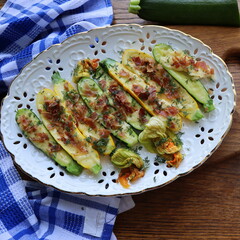 Fried zucchini stuffed with minced meat, cheese and bacon on wooden background