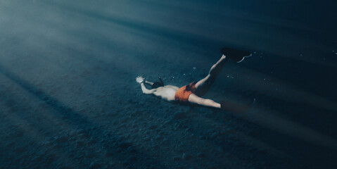 Boy swims in apnea underwater in the ocean