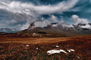 Dramatic sky and landscape image surrounding rock mountain and valley
