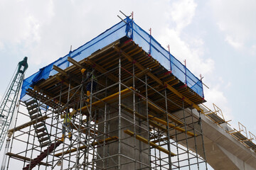 PENANG, MALAYSIA -JULY 2, 2021: The mega infrastructure structure is under construction. Construction workers are carrying out work with strict safety regulations. Temporary staging is installed. 