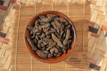 Dried edible mopane worms (Gonimbrasia belina), a type of emperor moth, a popular African delicacy - obrazy, fototapety, plakaty