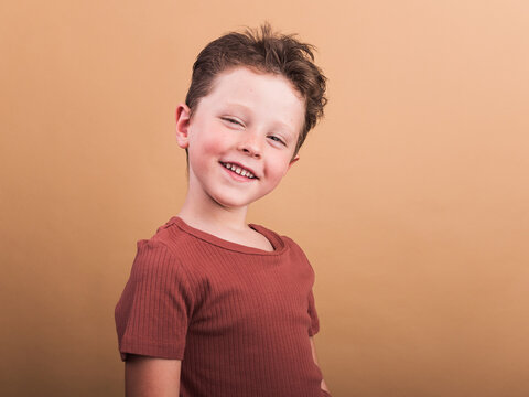 Smiling boy in t shirt on beige background