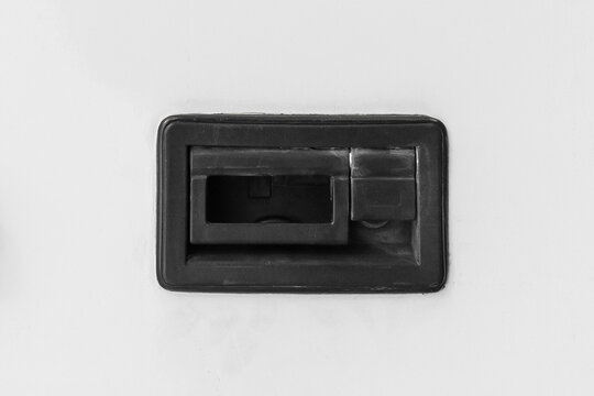 Modern black iron door handle in a rubberized frame of the luggage compartment of the transport