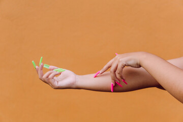 Woman with colorful manicure gently touching hand