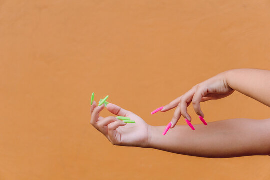 Woman with colorful manicure gently touching hand