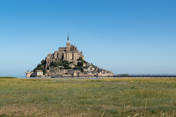 Summer view  of the famous historic Mont-Saint-Michel on the background of the blue sky.Saint...