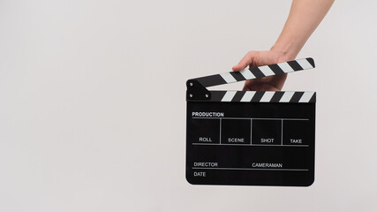 Hand is holding Black clapperboard or movie slate on white background.