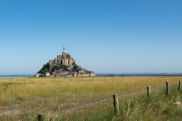 Summer view  of the famous historic Mont-Saint-Michel on the background of the blue sky.Saint...