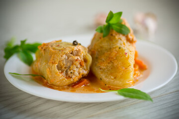 stewed in gravy stuffed peppers in a plate on a wooden table
