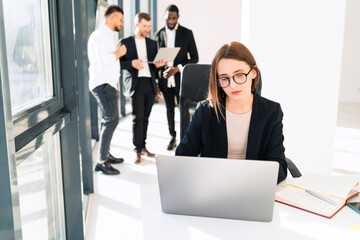 The secretary works in the office at the laptop