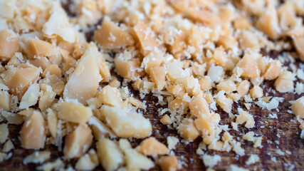 Chopped up peanuts in various pieces and sizes, on a dark wooden board. Great for adding as garnish on a stir fry. Food and asian cuisine concept.