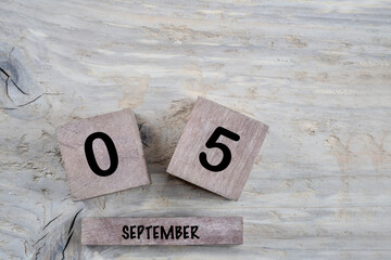 cube calendar for september on wooden background with copy space