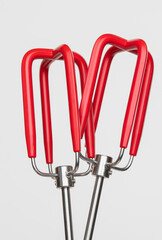 Bright red mixer beaters on a white background