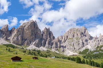 Alta Badia (Dolomiti) - August: Beautiful summer mountain view of Passo Sella and high peak Sassopiatto and Sassolungo, Langkofel, Dolomiti, Sella group. Green meadows and pastures, alpine dolomites