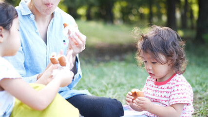 公園でドーナツを食べる家族／ピクニック