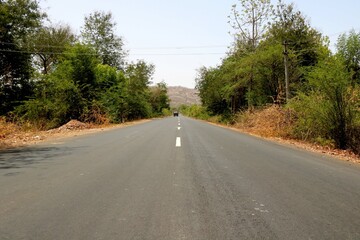 Rural Roads in India leading to the village at the distance
