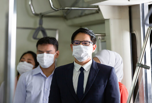 Group Of Asian Business People Wearing Face Protective Mask For Protection From Virus Disease On Subway Train, Public Transport During Coronavirus, COVID 19 Outbreak. Business, Health, Safety Concept