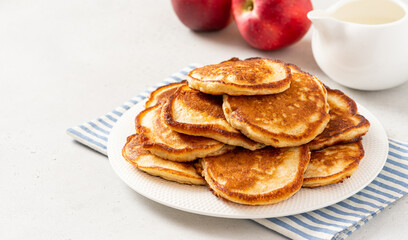 Homemade apple pancakes in a white plate on a gray concrete background. Copy space for text. Tasty breakfast