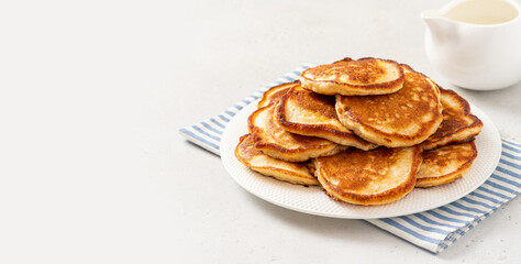Fototapeta na wymiar Homemade pancakes in a white plate on a gray concrete background. Copy space for text. Tasty breakfast