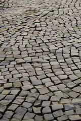 Gray old beautiful grunge block stone pavement in St Petersburg on canal front. Vertical photo.Natural background