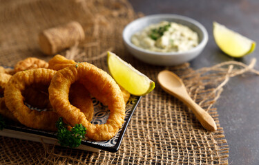 Homemade calamari with tartar sauce. Fresh homemade calamari with homemade tartar sauce and lemon.