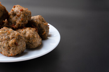 Chicken kofta meatballs mixed with ingredients of onions, garlic fresh herbs and spices mixture on black background