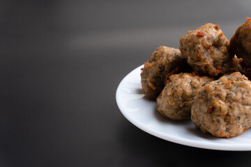 Chicken kofta meatballs mixed with ingredients of onions, garlic fresh herbs and spices mixture on black background