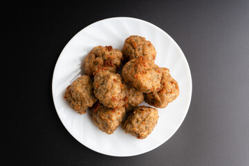 Chicken kofta meatballs mixed with ingredients of onions, garlic fresh herbs and spices mixture on black background
