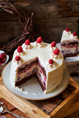 Chocolate raspberry cake with raspberry cheesecake layer. Decorated with berries. Side view