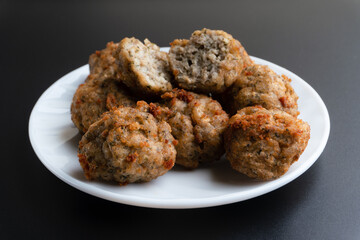 Chicken kofta meatballs mixed with ingredients of onions, garlic fresh herbs and spices mixture on black background