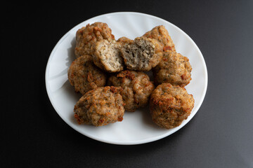 Chicken kofta meatballs mixed with ingredients of onions, garlic fresh herbs and spices mixture on black background