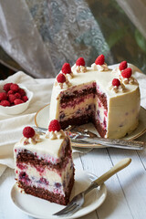 Chocolate raspberry cake with raspberry cheesecake layer. Decorated with berries. Side view