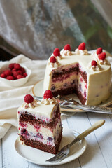 Chocolate raspberry cake with raspberry cheesecake layer. Decorated with berries. Side view