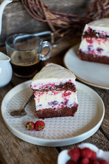 Chocolate raspberry cake with raspberry cheesecake layer. Decorated with berries. Side view