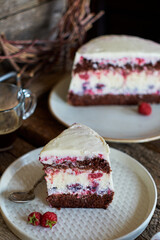 Chocolate raspberry cake with raspberry cheesecake layer. Decorated with berries. Side view