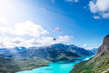 A paragliderpilot is flying over Besseggen in Jotunheimen. A famous national park in Norway