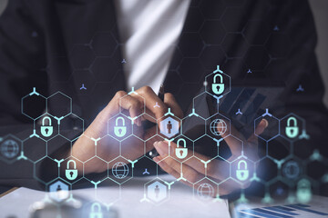 A businesswoman in formal wear checking the phone to sign the contract to prevent probability of risks in cyber security. Padlock Hologram icons over the working desk.