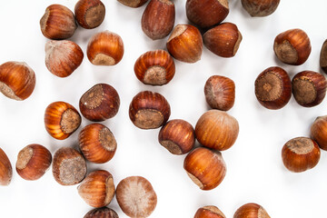Hazelnuts in their hard brown shells. Nuts flat lay composition on a white background.