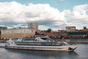 Naklejka premium A cruise ship sails along the Moscow river near a residential area