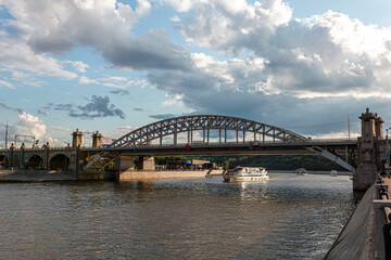 River cruise ship sails under the bridge