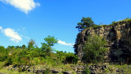 natürliche Landschaft mit Kalkfelsen , grünen Bäumen und Sträuchern unter malerischem blauen Himmel