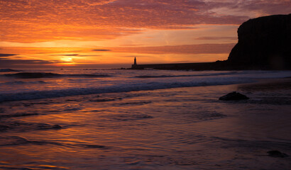 Fototapeta na wymiar A beautiful sunrise at Tynemouth's King Edward's Bay, as the sky explodes with color