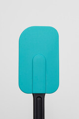 Teal and black silicone spatula on a white background
