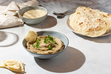 Baba ghanoush, babaganush or baba ganoush in gray bowl served with  oriental flatbread on concrete background. Turkish cuisine.