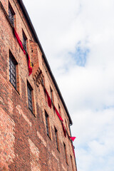 Gothic castle wall built of brick, flags attached to the wall, castle of Pomeranian dukes in Darłowo © LOGORYTM