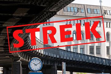 Banner with German text Streik (meaning strike) over an image with a clock under the curve of a...