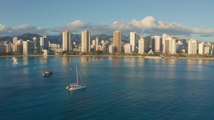 Panning aerial drone slowly flying over a colorful Honolulu Skyline while Sunset in Oahu, Hawaii...