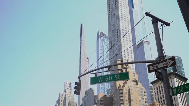 Traffic signs, one way arrow, street name 60th St., traffic light in New York.
